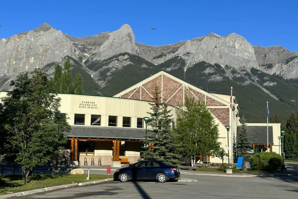 Canmore collegiate high school with rocky mountains in the background on summers day living in canmore alberta