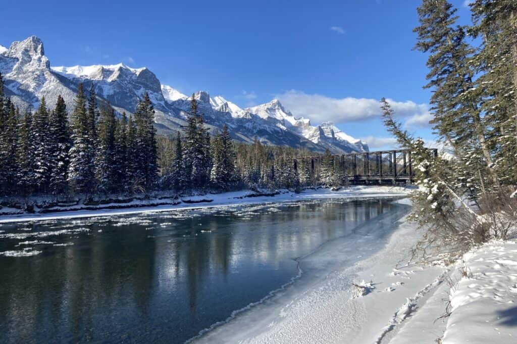 An icy bow river with canmore engine bridge in background