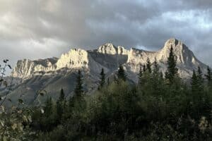 Dramatic ha ling peak with dark moody clouds in early morning light living in canmore alberta