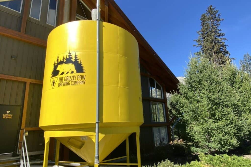 A large bright yellow outdoor beer vat at the grizzly paw brewing company one of the popular breweries in canmore alberta