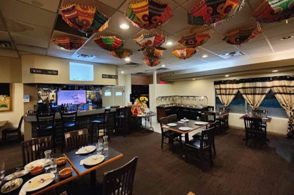 The interior of authentic indian cuisine with colourful umbrellas hanging from the ceiling one of the best indian restaurants in canmore