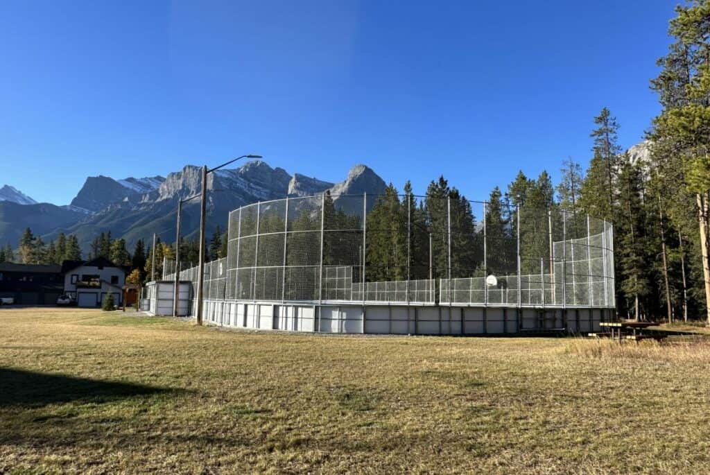 Larch ice rink against a backdrop of rocky mountains on summer day living in canmore alberta
