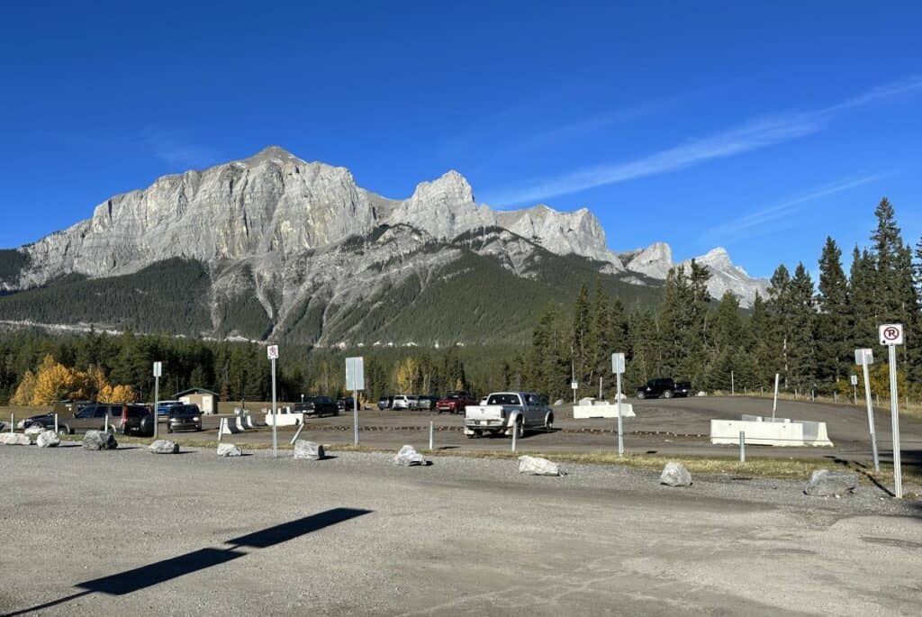 An empty quarry lake parking lot with rocky mountains in the background quarry lake loop canmore alberta