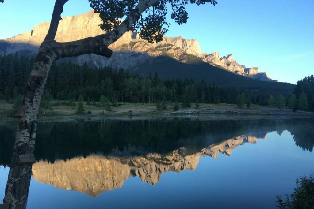 Blue sky in summer at quarry lake loop canmore east end rundle is reflected in the lake