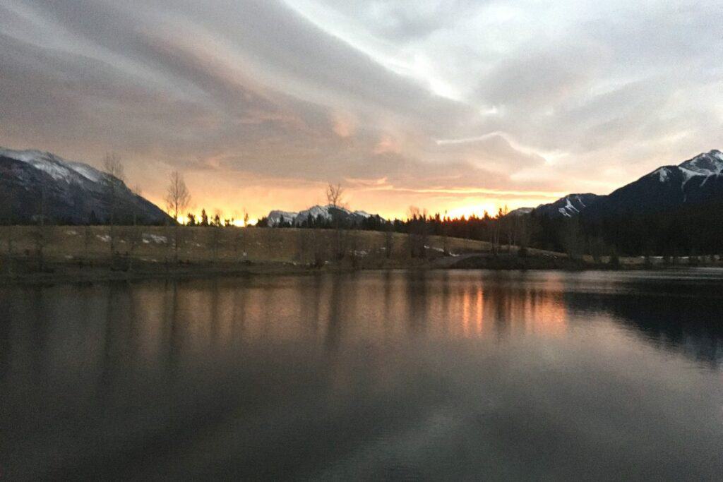 A bright yellow orange sunrise over quarry lake loop canmore