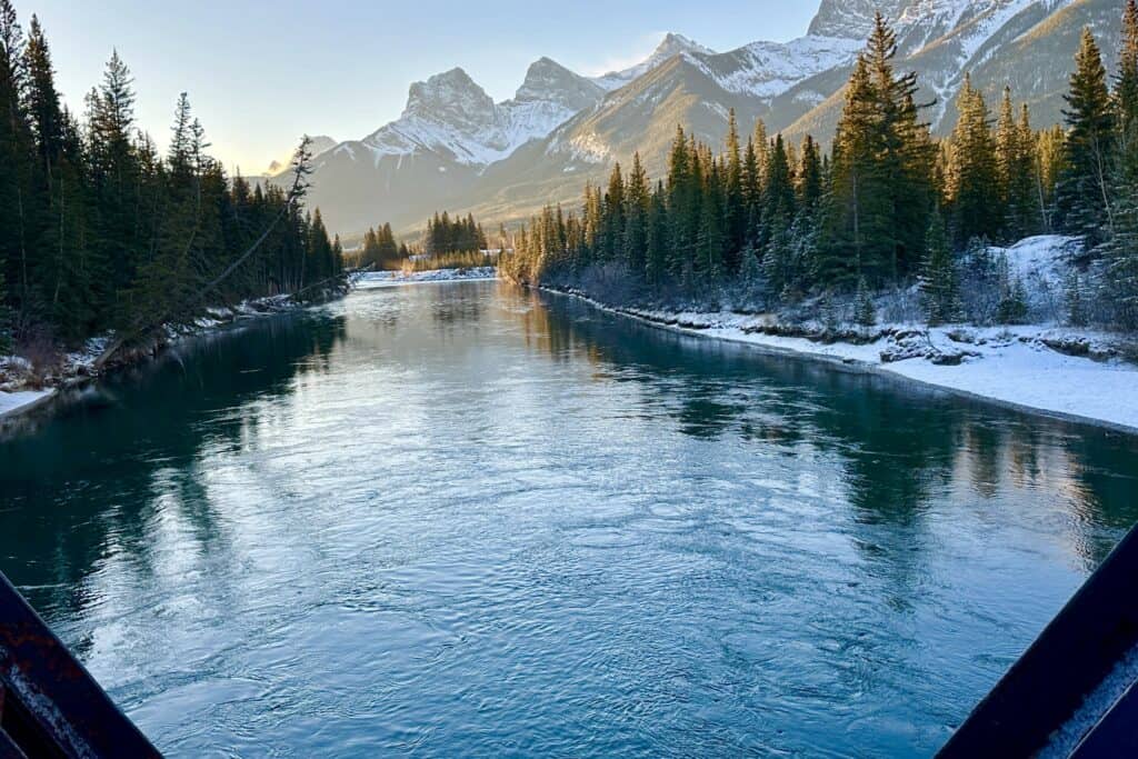 The bow river and three sisters peaks from canmore engine bridge in winter
